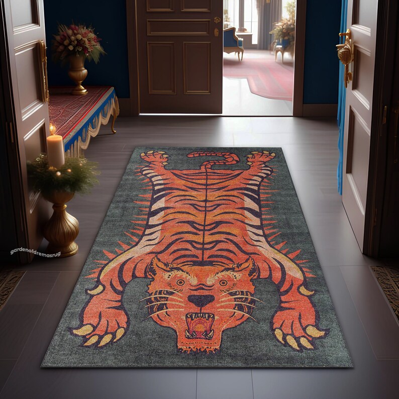 May include: A green and orange tiger rug with a detailed design. The rug is on a dark gray floor in a hallway.