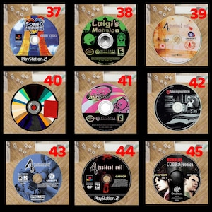 Pode incluir: Nove discos de videojogos, cada um com obras de arte e t&iacute;tulos &uacute;nicos. Os t&iacute;tulos incluem "Sonic Heroes", "Luigi's Mansion" e "Resident Evil". Os discos est&atilde;o dispostos numa grelha, mostrando v&aacute;rias capas e log&oacute;tipos de jogos.