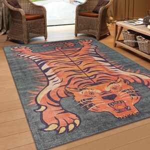May include: A gray rug with a large orange and black tiger print. The tiger is depicted with its mouth open and fangs showing. The rug has a distressed, vintage look.
