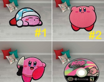 Puede incluir: Cuatro alfombras diferentes con temática de Kirby, en rosa y blanco. La primera alfombra muestra a Kirby durmiendo con un gorro azul y blanco. La segunda alfombra muestra a Kirby de pie con un cuerpo rosa y ojos blancos. La tercera alfombra muestra a Kirby sosteniendo un cuchillo con un cuerpo rosa y ojos blancos. La cuarta alfombra muestra un disco de videojuego de Kirby con un diseño rosa y blanco.