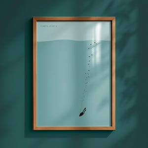 Può includere: Stampa artistica incorniciata raffigurante un subacqueo che scende in acqua turchese. Il design minimalista include bolle e una fila di punti, con coordinate in alto. La cornice in legno aggiunge un tocco naturale alla scena subacquea.