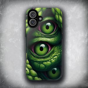 Può includere: Custodia per telefono con un design artistico e dettagliato di occhi di creatura. Il design presenta tre occhi verdi vibranti con pupille nere e dettagli rosa, su uno sfondo verde strutturato. La custodia ha una finitura lucida.