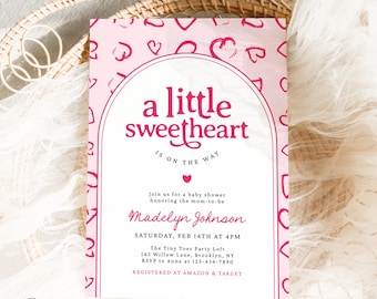 May include: A pink baby shower invitation with the text "a little sweetheart is on the way." The invitation features a pink heart pattern and the name "Madelyn Johnson." The event is on February 14th at 4 PM.