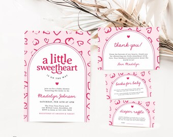 May include: Pink baby shower invitation set with a heart pattern. The invitation reads "a little sweetheart is on the way" and includes details for the event. Also included are thank you, books for baby, and diaper raffle cards.