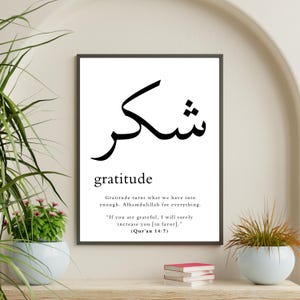May include: A black and white printable wall art print with the Arabic word for gratitude, "Shukr", and the English word "gratitude" below it. The print also includes a quote about gratitude from the Quran.