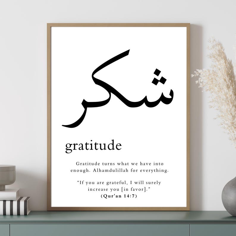 May include: A black and white printable wall art print with the Arabic word for gratitude, "Shukr", and the English word "gratitude" written below it. The print also includes a quote about gratitude from the Quran: "If you are grateful, I will surely increase you [in favor]." (Qur'an 14:7)