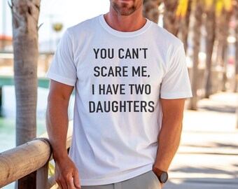 Puede incluir: Camiseta blanca con el texto "You can't scare me, I have two daughters" impreso en la parte delantera.