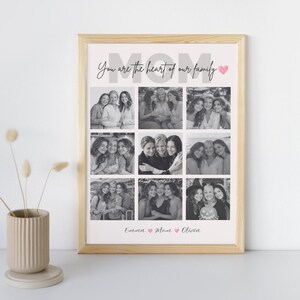 May include: A framed print with a light wood frame. The print features a collage of black and white photos of women. The word "MOM" is at the top, with the phrase "You are the heart of our family" above the photos. The names "Emma Mom Olivia" are at the bottom.