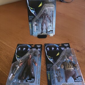 May include: Three Spawn action figures in original blister packaging. One figure is Spawn with combat assault weapons, one is a figure with a grave digging shovel, and one is a Clown figure with snap-on parts that transform into Violator.