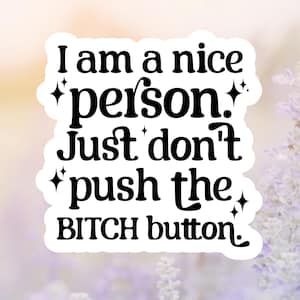 May include: A white sticker with black text that reads "I am a nice person. Just don't push the BITCH button." The sticker has a blurred background of purple flowers and a soft, out-of-focus light.