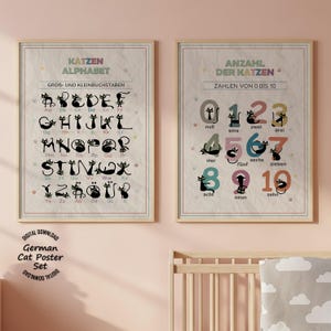 Könnte beinhalten: Zwei gerahmte Lernposter mit Illustrationen schwarzer Katzen, die in das deutsche Alphabet und die Zahlen von null bis zehn integriert sind. Die Poster haben einen hellen, strukturierten Hintergrund mit kleinen bunten Pfotenabdrücken.