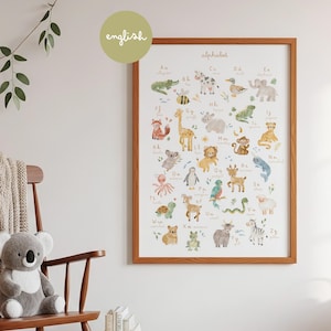 Cozy nursery room decor mockup featuring the watercolor alphabet poster framed on a neutral wall. Next to a wooden rocking chair with a plush koala teddy bear, green leaves, and natural warm lighting. Perfect gender-neutral kids bedroom wall decor.