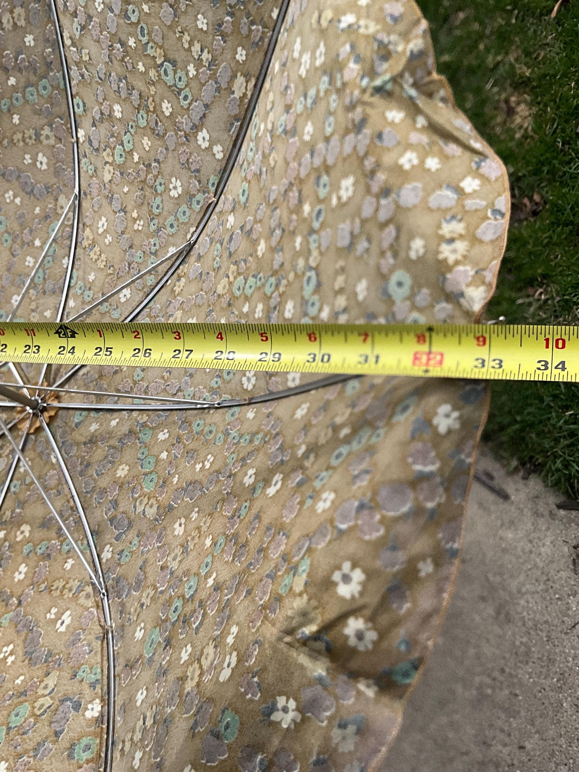 Parasol vintage en tissu fleuri, photographié à l'intérieur Photo Stock