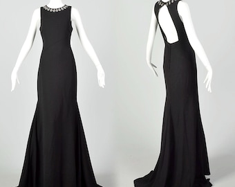Vestido de noche formal sin mangas con escote en la espalda y cola de Pronovias, color negro sirena.