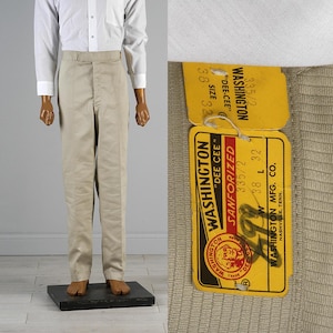 Pode incluir: Calças bege de cintura subida com uma camisa branca de botões. Uma etiqueta de papel amarela presa ao tecido apresenta o texto WASHINGTON DEE CEE, SANFORIZED, 335/2, W 38, L 32, e WASHINGTON MFG. CO. NASHVILLE, TENN.