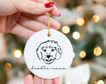 Puede incluir: Adorno navideño de cerámica blanca con un dibujo de línea negra de un perro caniche y el texto "doodle mama".