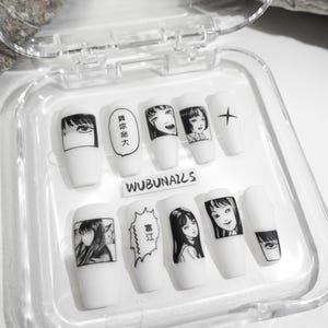 handmade matte press-on nails with a gothic Halloween theme. Each nail features black and white manga illustrations inspired by Junji Ito's Tomie, printed in comic panel style. Nails are sharp coffin shape, with high contrast matte finish and eerie graphic details. Ideal for cosplay, horror-themed birthday party, Halloween costumes or comic conventions. Customizable design by wubunails for gothic lovers. A perfect glue-on faux acrylic nail set for fans of Japanese horror and manga.