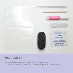 May include: A nail kit with various tools on a white surface. Includes two sheets of gel glue, a nail file, a cuticle removal stick, nail glue, an alcohol prep pad, and a black nail buffer. The text "Free Tools Kit" is visible.