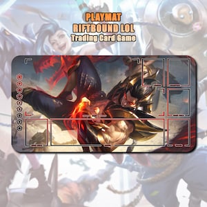 May include: Rectangular playmat with a fantasy illustration featuring a character in gold armor and red accents. The playmat has designated zones for a trading card game, with the text "PLAYMAT RIFTBOUND LOL Trading Card Game".