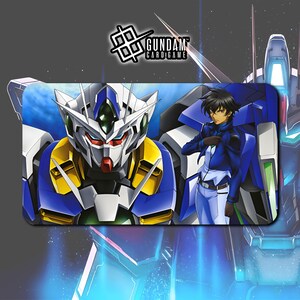 Puede incluir: Alfombrilla rectangular para el juego de cartas Gundam con una ilustraci&oacute;n detallada de un robot Gundam y un personaje con uniforme azul. La alfombrilla tiene una combinaci&oacute;n de colores azul y blanco con toques de amarillo y rojo. El logotipo de Gundam Card Game est&aacute; en la esquina superior izquierda.