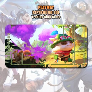 Op de afbeelding: Een rechthoekige speelmat voor het Riftbound LOL Trading Card Game. De mat heeft een kleurrijke illustratie van een stripfiguur met een groene hoed en rode sjaal. De achtergrond bevat paarse wolken en groen gebladerte.