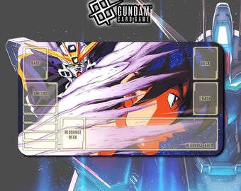May include: A rectangular Gundam card game playmat featuring a detailed illustration of a Gundam robot and character. The mat has designated areas labeled "Base", "Shields", "Resource Deck", "Deck", "Trash", and "Resource Area". The Gundam Card Game logo is at the top.