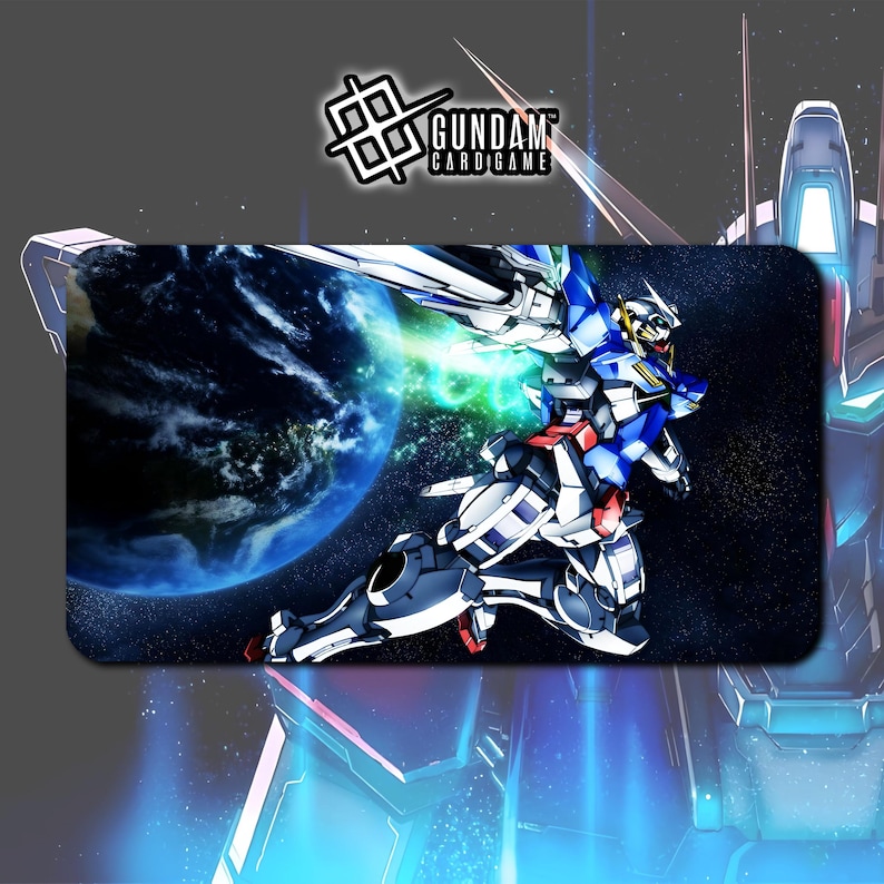 Puede incluir: Alfombrilla rectangular de juego Gundam Card Game con una ilustraci&oacute;n din&aacute;mica de un robot mecha azul, blanco y rojo en una escena espacial con un planeta y efectos de energ&iacute;a verde. El logotipo de Gundam Card Game est&aacute; en la esquina superior izquierda.
