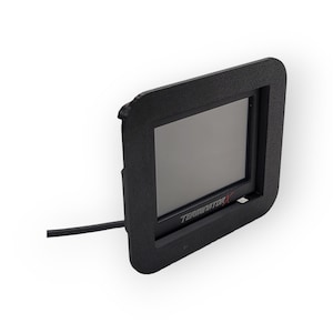 Pode incluir: Dispositivo retangular preto com uma tela e um cabo preto. O dispositivo tem o texto "TERMINATOR X" na parte inferior.