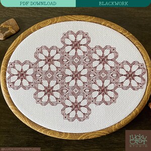 May include: A close-up of a finished embroidery project in a wooden hoop. The design is a geometric pattern of interlocking squares and circles in a burgundy color. The background is white.