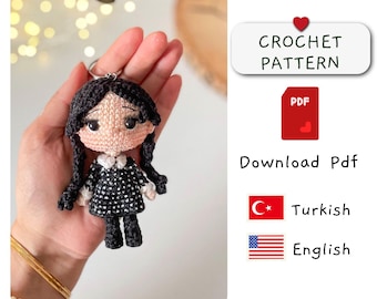 May include: Crochet pattern for a black and white doll with long black hair, wearing a black dress with white collar. The pattern is available in Turkish and English. Download PDF.