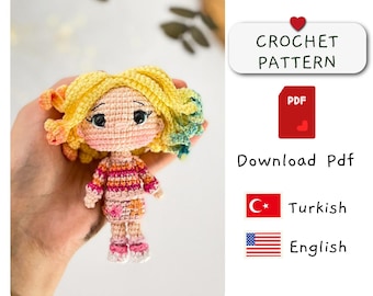 May include: Crochet pattern PDF download for a colorful amigurumi doll with yellow hair, pink and red striped sweater, and a pink and orange floral skirt. The pattern is available in Turkish and English.