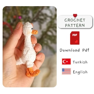 Puede incluir: Patrón de crochet para un ganso blanco con patas naranjas. El patrón está disponible en turco e inglés. Descarga el patrón PDF.