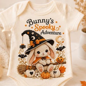 May include: A cream-colored baby bodysuit featuring a graphic of a bunny wearing a black witch hat, sitting on a broomstick with pumpkins, bats, and stars. The text above the illustration reads Bunny's Spooky Adventure in orange and black.