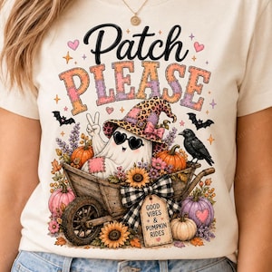 May include: A cream-coloured t-shirt featuring a graphic of a ghost in a leopard print hat sitting in a wooden wheelbarrow with pumpkins, sunflowers, and a crow. The text reads Patch PLEASE and a tag says GOOD VIBES & PUMPKIN RIDES.