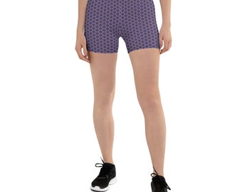 May include: Purple athletic shorts with a black geometric pattern. The shorts are worn by a person with bare legs and black sneakers.
