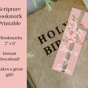 May include: A pink bookmark with a wooden cross and floral design. The text "Jesus is my Savior" is written on the bookmark. The bookmark is 2 inches by 6 inches.
