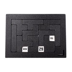 Op de afbeelding: Zwart puzzelbord met een witte kalenderdatum van 29 november en de dag van de week, vrijdag, zichtbaar.