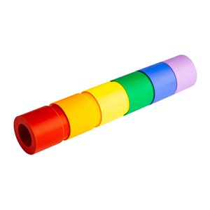 Pode incluir: Um conjunto de seis anéis empilháveis coloridos em um padrão de arco-íris. Os anéis são feitos de plástico e são projetados para o jogo das crianças.