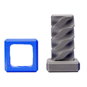 Puede incluir: Un cuadrado de plástico azul con un agujero cuadrado en el centro y un objeto de plástico gris con un diseño en espiral en la parte superior.