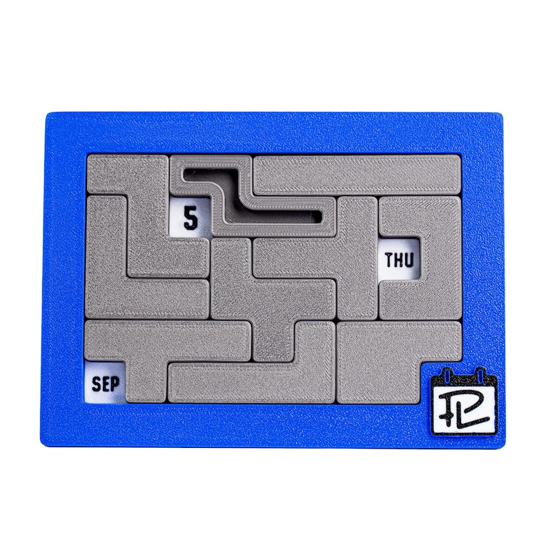 Op de afbeelding: Een blauwe plastic kalenderpuzzel met een grijs doolhof. Het doolhof heeft het nummer "5" en de woorden "SEP" en "THU" erin. De puzzel heeft een kalenderpictogram met het nummer "12" erop.