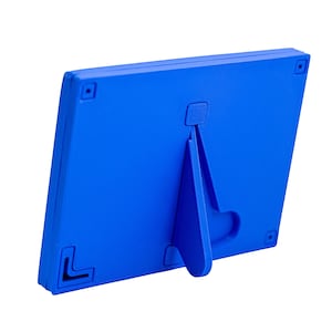 Op de afbeelding: Een blauwe plastic fotolijst met een ingebouwde standaard. De standaard klapt uit om de lijst rechtop te zetten.