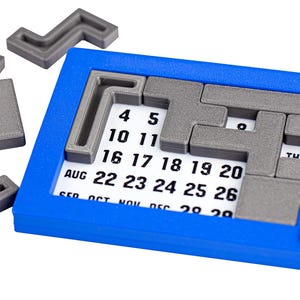 Op de afbeelding: Een blauwe kalenderpuzzel met grijze puzzelstukken. De puzzelstukken zijn L-vormig en passen in het kalenderrooster. De kalender toont de maanden augustus tot en met december.