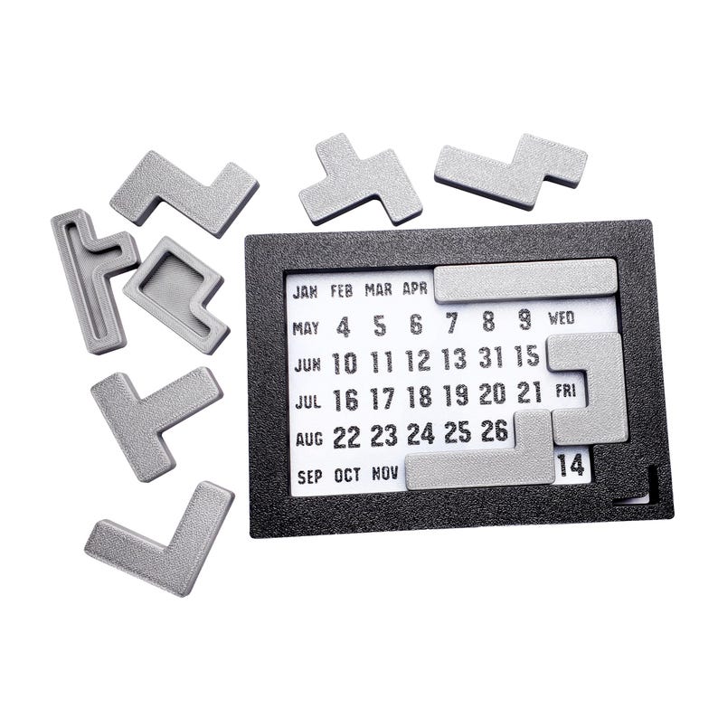 Op de afbeelding: Een zwarte kalender met een witte achtergrond en zilveren puzzelstukken. De kalender toont de maanden januari tot en met november en de dagen van de week. De puzzelstukken zijn vierkant en rechthoekig en zijn gerangschikt in een rasterpatroon. De kalender is een leuke en interactieve manier om data en afspraken bij te houden.
