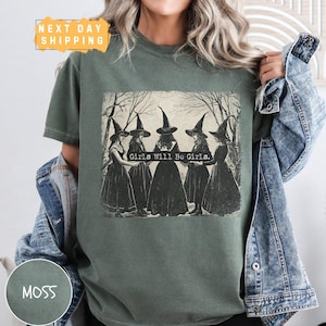 a woman wearing a green t - shirt with witches on it