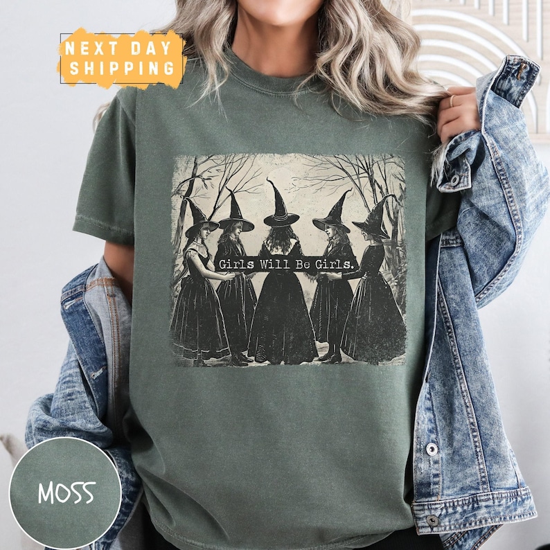 a woman wearing a green t - shirt with witches on it