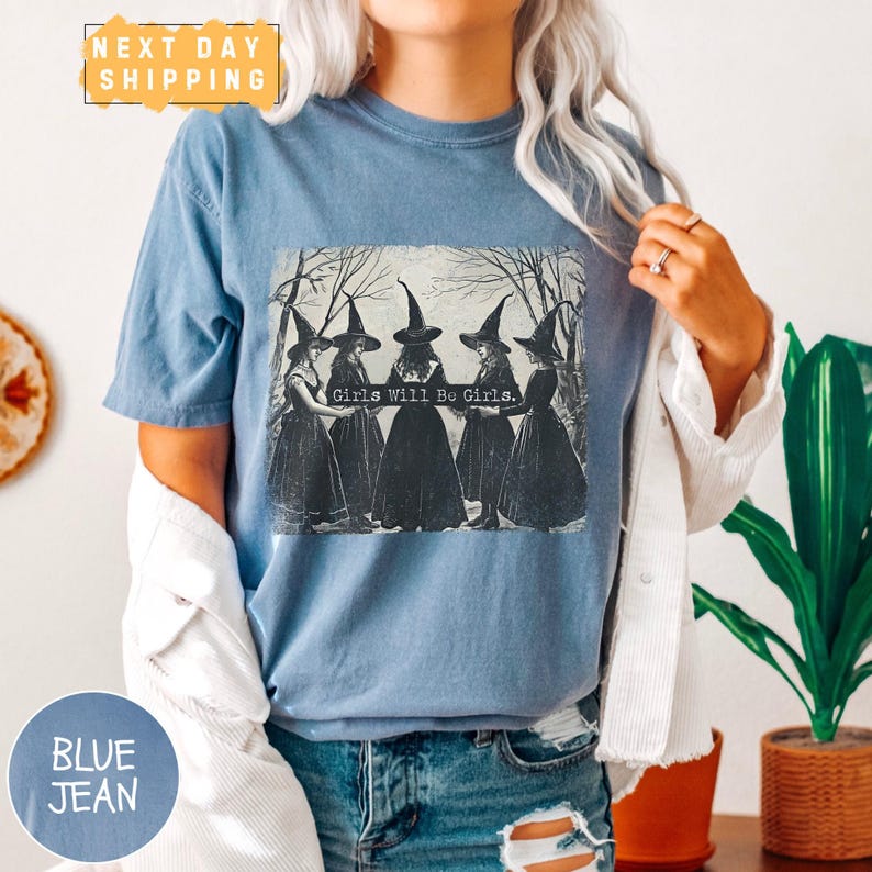 a woman wearing a blue t - shirt with witches on it