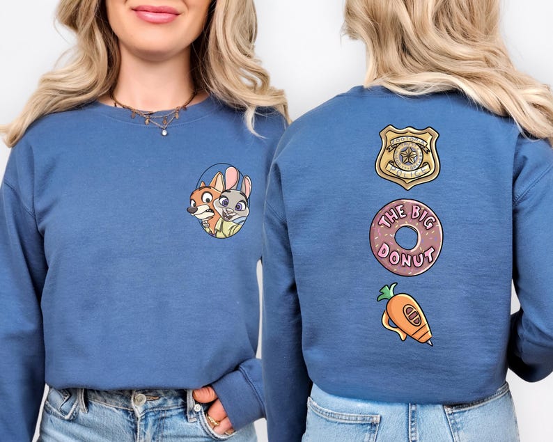 A woman wearing a blue sweater with cartoon characters and a police badge on the back.
