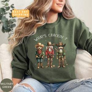a woman sitting on a couch wearing a green sweatshirt