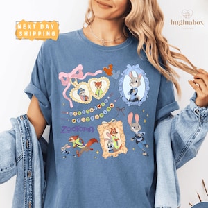 A woman wearing a blue t-shirt with various cartoon animal characters and a heart-shaped ribbon design.