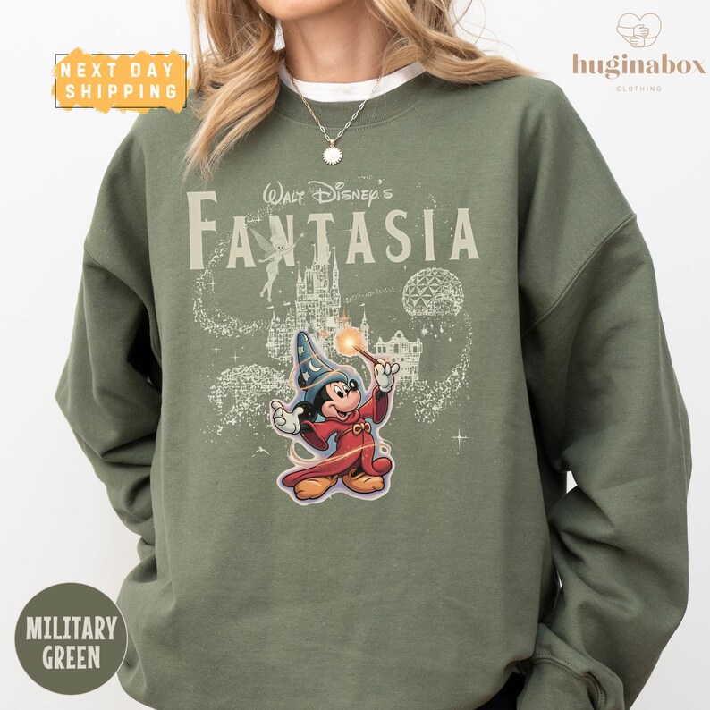 A person wearing a green sweatshirt with a Disney character and the text "Disney's Fantaasia" printed on it.